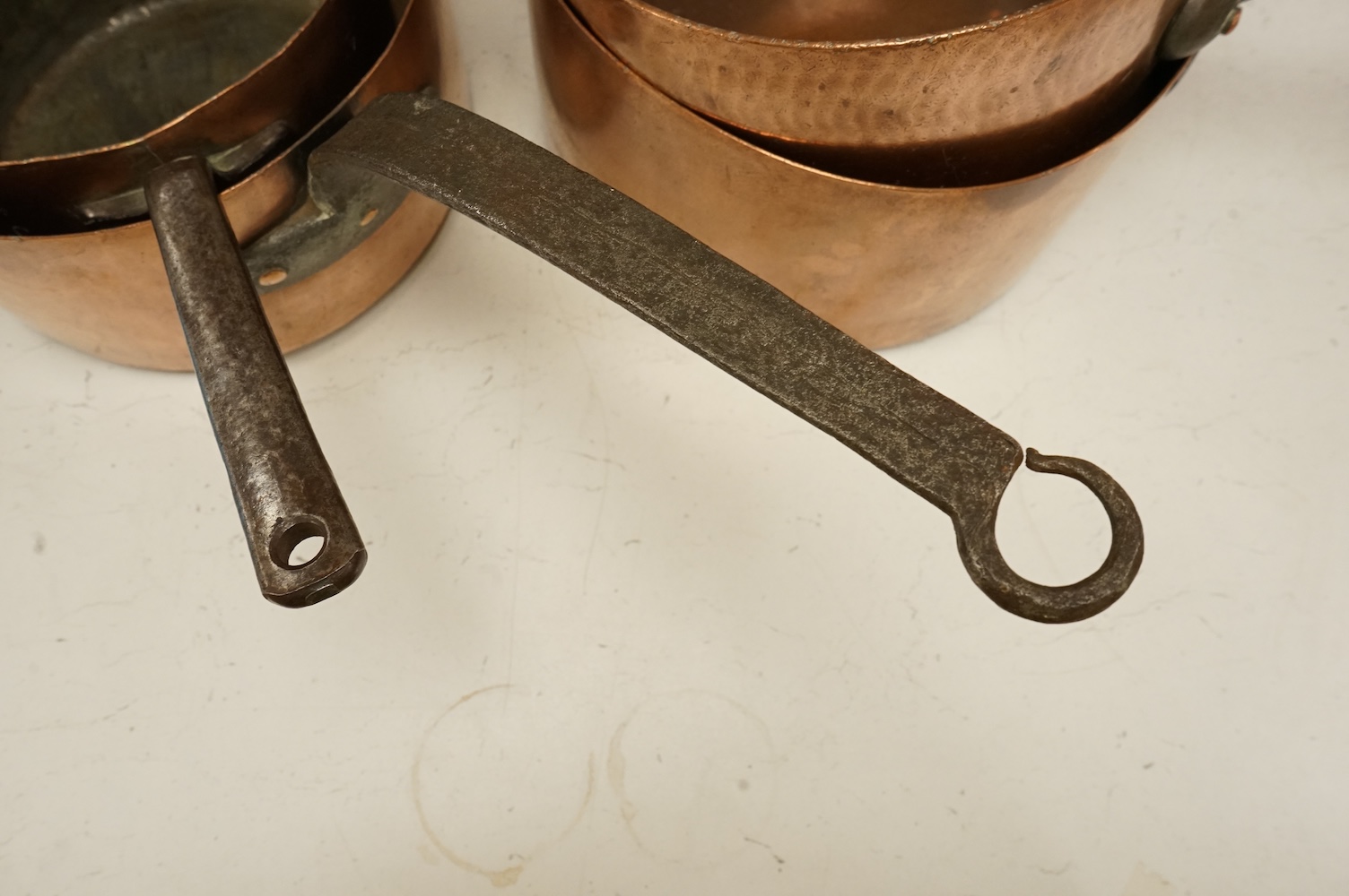 A graduated group of four large copper saucepans